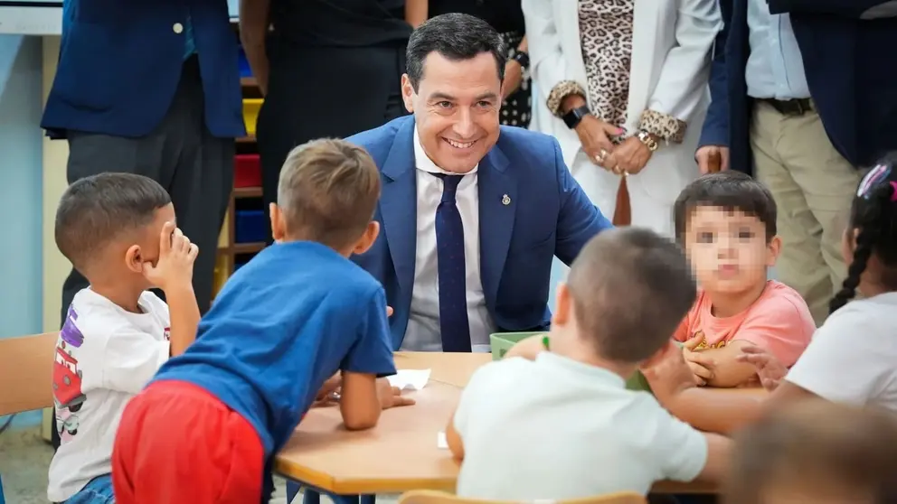 Juanma Moreno, rodeado de ni&ntilde;os en un colegio
