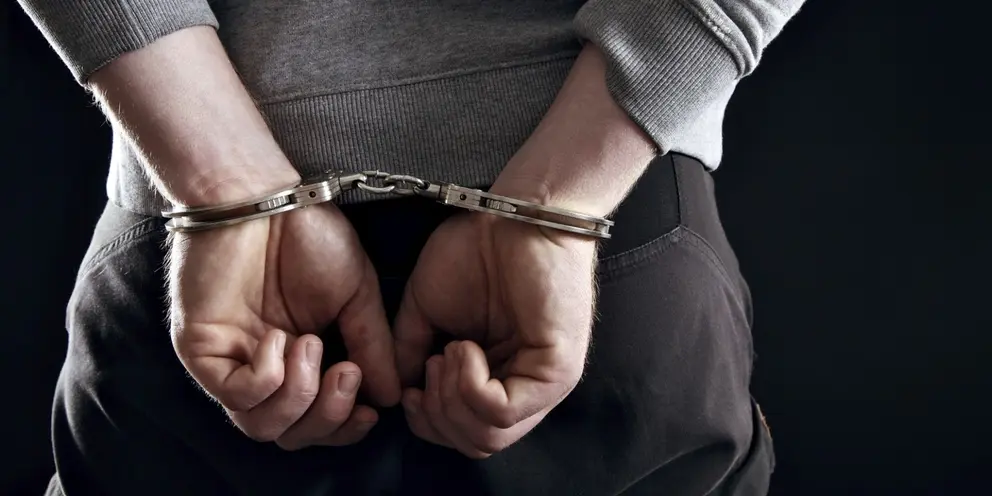 Outlaw's Hands Locked in Handcuffs