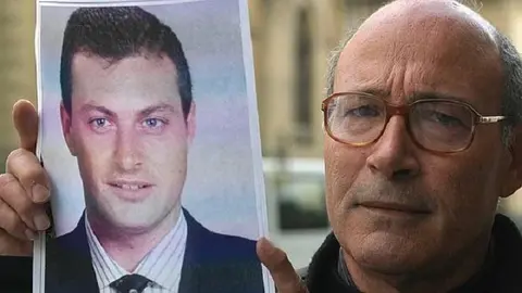 Francisco Holgado sosteniendo una imagen de su hijo Juan