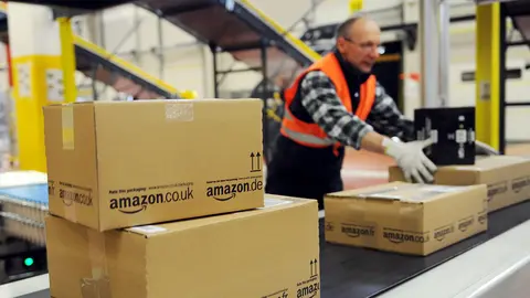epa03561427 FILE) A file photo dated 20 December 2010 showing an employee of the online-retailer Amazon putting packages onto a conveyor band at the logistics centre in Bad Hersfeld, Germany. Amazon posted a sales increase of 22-per-cent over the critical fourth quarter 30 January 2013 as customers snapped up 21.27-billion dollars worth of goods from the leading web retailer. Operating income grew 56 per cent to 405 million dollars, from 260 million a year earlier. But net income was down 45 per cent to 97 million dollars as the company continued to pursue greater market share with low profit margins, while also ramping up investment in infrastructure and logistics centres. That strategy is at the core of the company's long-term growth plan, which is starting to bear fruit, said founder and CEO Jeff Bezos.  EPA/UWE ZUCCHI