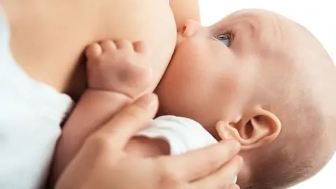 Baby feeds on MOM's breasts