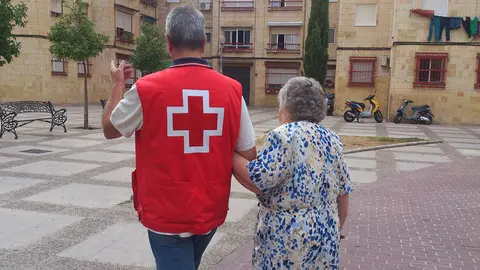 Voluntario de Cruz Roja junto a una mujer mayor