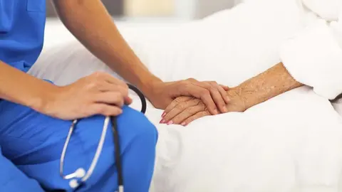 medical doctor comforting senior patient