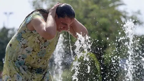 GRA163. C&Oacute;RDOBA, 05/07/2015.- Una mujer se refresca en una de las fuentes de la ciudad debido a las altas temperaturas que se registran en C&oacute;rdoba, dentro de la ola de calor que se registra en casi toda Espa&ntilde;a..- EFE/Salas
