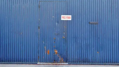 GRAFAND006. SEVILLA, 30/08/2019.- Fachada y puerta de la f&aacute;brica Magrudis, en el Pol&iacute;gono sevillano de El Pino, empresa fabricante de la carne mechada contaminada con listeriosis, que ha sido precintada por el Ayuntamiento de Sevilla al haber formalizado hoy viernes ante la Fiscal&iacute;a una denuncia contra esta factor&iacute;a por un delito contra la salud p&uacute;blica. EFE/Jos&eacute; Manuel Vidal