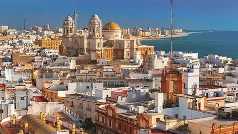 Aerial panorama of the old city rooftops and Cathedral de Santa Cruz in the morning, as seen from tower Tavira in Cadiz.