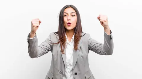 young pretty woman celebrating an unbelievable success like a winner, looking excited and happy saying take that! isolated against white wall