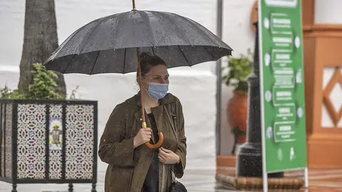 Una mujer se protege de la lluvia en Andaluc&iacute;a