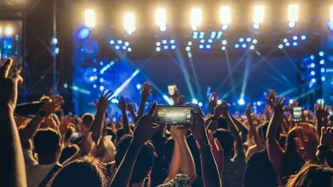 Concert crowd of Music fanclub hand using cellphone taking video record or Live stream with superstar songer, happy new year, christmas and festival concept