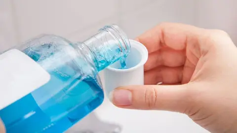Close-up Of Person's Hand Pouring Liquid In Container