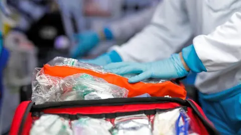 Una sanitaria prepara el material en la ambulancia