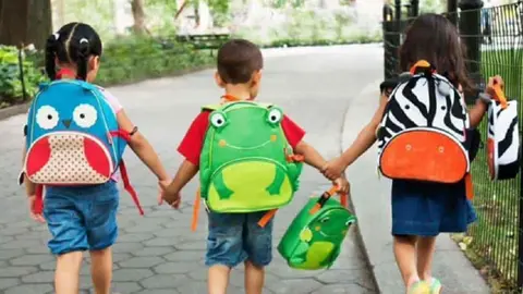 Ni&ntilde;os con mochilas