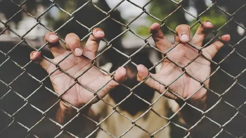 Persona en una valla | Imagen de Archivo