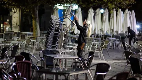 Una camarera cerrando la terraza de un bar | Foto: Archivo
