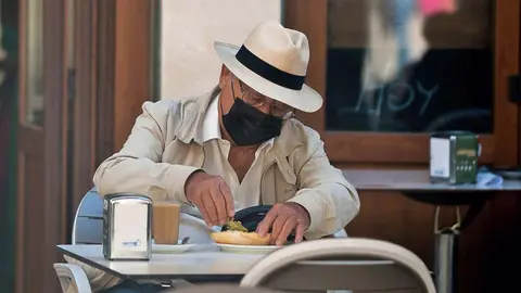 Un hombre desayunando en un bar / Archivo