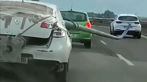 Renault de color blanco portando una farola que sobresale del veh&iacute;culo