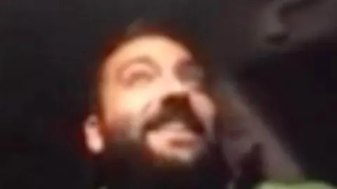 Juan Ram&oacute;n Barroso Morales, delegado de fiestas del PSOE en Arcos de la Frontera, asistiendo online al pleno municipal desde el asiento del conductor de un coche