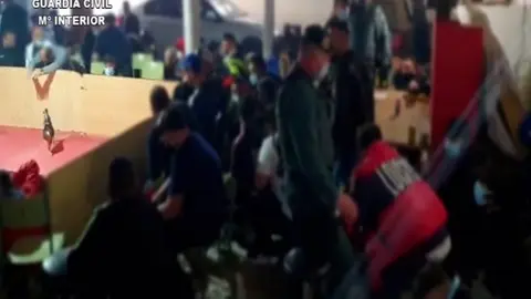 28/01/2021 Almer&iacute;a.-Sucesos.-Disuelven una pelea de gallos con casi 90 personas sin normas covid y que portaban drogas y armas.

   ALMER&Iacute;A, 28 (EUROPA PRESS) 

   La Guardia Civil ha disuelto en El Ejido (Almer&iacute;a) una pelea de gallos ilegal en la que se concentraban 89 personas, entre ellas menores de edad, quienes incumpl&iacute;an las medidas relativas a la crisis sanitaria por covid-19 de distancia social, uso de mascarilla y limitaci&oacute;n de aforo, toda vez que algunas de ellas portaban armas y drogas, por lo que se han interpuesto hasta 260 denuncias.

   La actuaci&oacute;n llevada a cabo en el Pozo de la T&iacute;a Manolica, dentro del n&uacute;cleo ejidense de Matagorda, se desarroll&oacute; por los agentes tras recibir un aviso an&oacute;nimo sobre la gran concentraci&oacute;n de personas detectada en una nave industrial de la zona, seg&uacute;n ha indicado el Instituto Armado en una nota.

   Los agentes se desplazaron con urgencia hasta el lugar donde sorprendieron a cerca de un centenar de personas, entre ellos menores de edad, que disputaban una pelea de gallos ilegal "sin cumplir entre otras las medidas relativas a la crisis sanitaria por covid-19".

   En el desarrollo de la investigaci&oacute;n los agentes localizaron el cuerpo sin vida de un gallo con heridas recientes y 21 gallos con vida, a los que se le hab&iacute;an practicado cortes en las crestas y afilado artificial de los espolones.

   Ante la presencia de los agentes, numerosas personas lanzaron al suelo multitud de objetos como navajas, estupefacientes y utensilios de afilar que finalmente fueron reconocidos por sus propietarios, al igual que la mayor&iacute;a de los animales.

   Por estos hechos los agentes han investigado a una persona por delito relativo a la protecci&oacute;n de la flora, fauna y animales dom&eacute;sticos y han confeccionado 260 denuncias relativas a la protecci&oacute;n animal en Andaluc&iacute;a, tenencia y consumo de estupefacientes y por incumplimiento de las medidas sanitarias relativas a la crisis covid-19. Las diligencias instruidas se han puesto a d