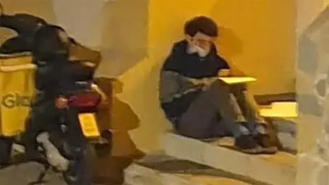 Repartidor de Glovo estudia bajo una farola en M&aacute;laga | Foto de Pedro G. D&iacute;az