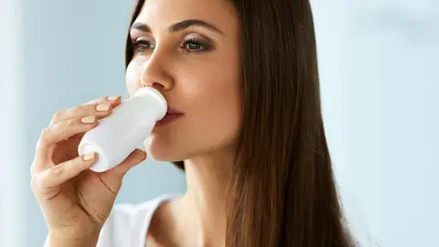 Mujer tomando probi&oacute;tico