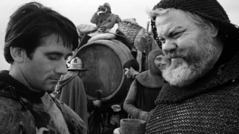 Orson Welles como Fasltaff, en la pel&iacute;cula Campanadas a medianoche, ante una bota de vino