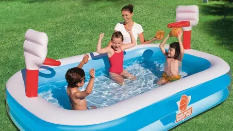 Ni&ntilde;os en piscina con canasta de baloncesto