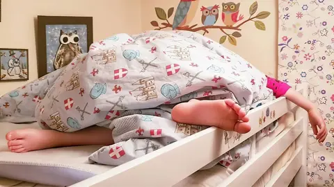 Ni&ntilde;a durmiendo en cama litera