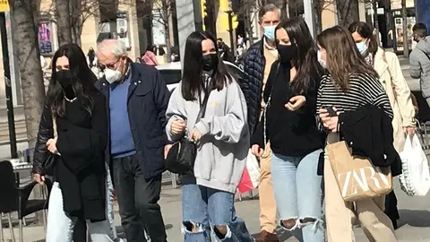J&oacute;venes con mascarilla paseando