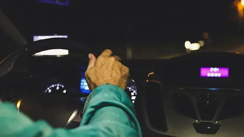 Hombre conduciendo un coche de noche - Archivo
