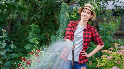 Mujer regando el jard&iacute;n