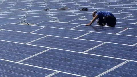 Un trabajador colocando placas solares