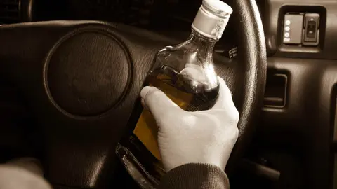 Un conductor con una botella de alcohol