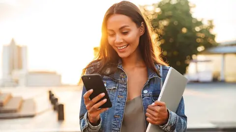 Una joven mirando su tel&eacute;fono m&oacute;vil
