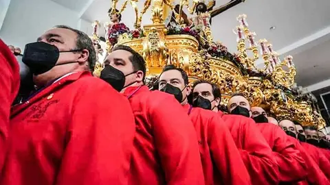Juanma Moreno carga emocionado al Cristo de la Exaltaci&oacute;n en la Magna de M&aacute;laga