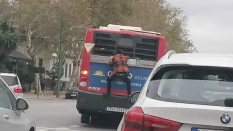 Una persona se cuelga de un autob&uacute;s en marcha en Sevilla