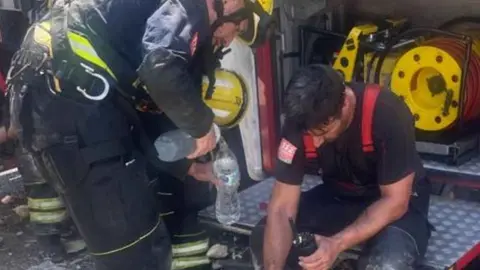 Bomberos tras rescatar al camionero accidentado
