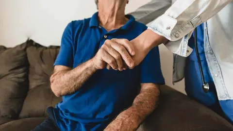 Una cuidadora con un anciano | Archivo