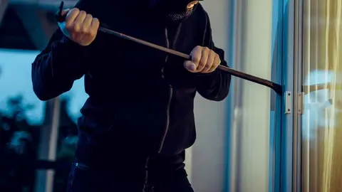 Un ladr&oacute;n forzando una ventana