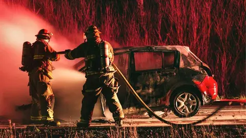 Un coche ardiendo en una foto de archivo