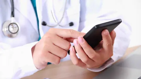 Un m&eacute;dico con un m&ograve;vil