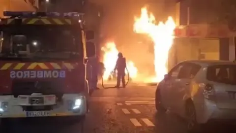 Impactante incendio en Granada. Arde un coche circulando y las llamas llegan a la casas