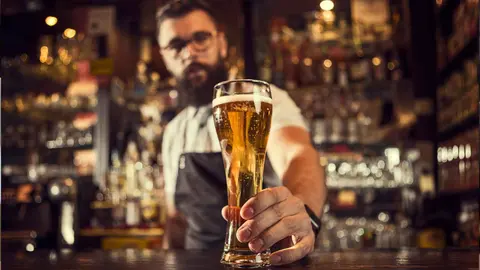 Un camarero sirviendo una cerveza