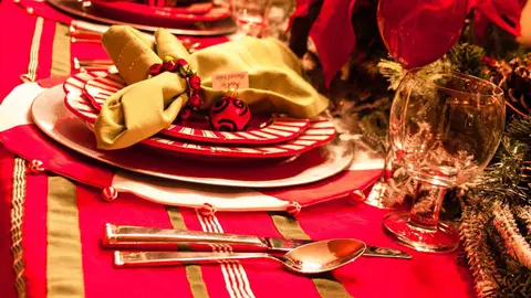 Mesa con mantel y cuberter&iacute;as con dise&ntilde;os t&iacute;picos de Navidad