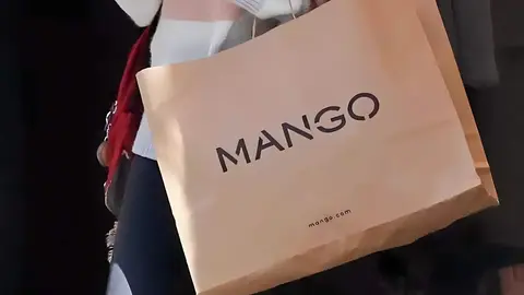 Mujer en invierno con bolsa de compra de Mango