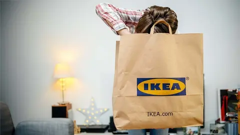 Mujer abre bolsa de IKEA en casa