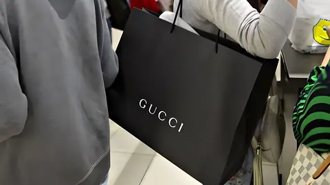 Mujer amante de Gucci con bolsa de compra de la marca