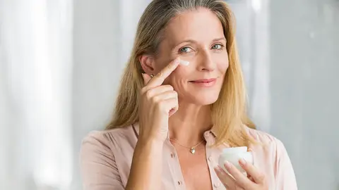 Mujer se aplica cremas anti-edad en la cara