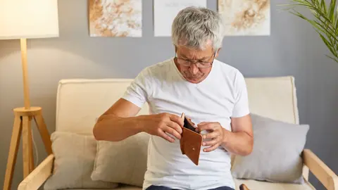 Hombre jubilado mira su cartera