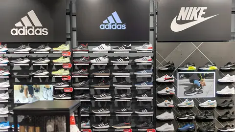 Panel de zapatillas Adidas y Nike en tienda de moda deportiva y casual