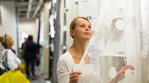 Mujer eligiendo las cortinas adecuadas para su casa en IKEA